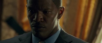Movie still from “The Kingdom” (2007), directed by Peter Berg – A person wearing a suit and tie; Close Up shot, Over the shoulder angle