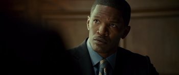 Movie still from “The Kingdom” (2007), directed by Peter Berg – A person wearing a suit and tie; Close Up shot, Over the shoulder angle