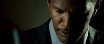 Movie still from “The Kingdom” (2007), directed by Peter Berg – A person wearing a suit and tie; Extreme Close Up shot, Low angle