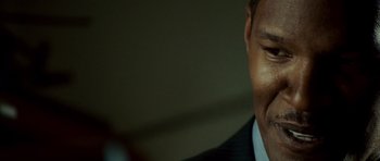 Movie still from “The Kingdom” (2007), directed by Peter Berg – A person wearing a suit and tie; Close Up shot, Over the shoulder angle