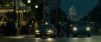 A taxi cab is stopped on a city street at night