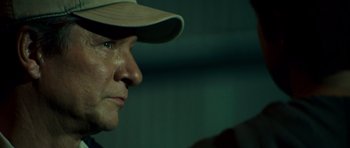 Movie still from “The Kingdom” (2007), directed by Peter Berg – A person wearing a hat; Close Up shot, Over the shoulder angle