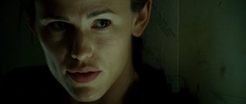 Movie still from “The Kingdom” (2007), directed by Peter Berg – A person's face with a dark background; Close Up shot, Low angle