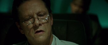Movie still from “The Kingdom” (2007), directed by Peter Berg – A person wearing glasses and a white shirt; Close Up shot, Low angle