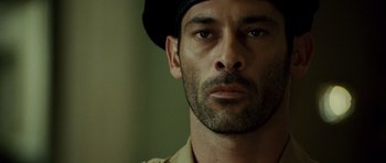 Movie still from “The Kingdom” (2007), directed by Peter Berg – A person wearing a hat; Close Up shot, Low angle