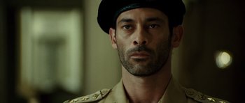 Movie still from “The Kingdom” (2007), directed by Peter Berg – A person wearing a hat; Close Up shot, Low angle