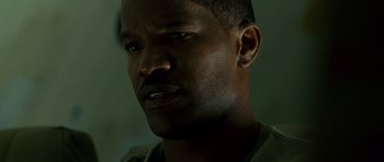 Movie still from “The Kingdom” (2007), directed by Peter Berg – A man's face in the dark; Close Up shot, Low angle