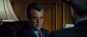 Movie still from “The Kingdom” (2007), directed by Peter Berg – A person wearing a suit and tie; Close Up shot, Over the shoulder angle