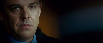 Movie still from “The Kingdom” (2007), directed by Peter Berg – A man's face in a dark room; Close Up shot, Over the shoulder angle