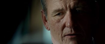 Movie still from “The Kingdom” (2007), directed by Peter Berg – A man's face with wrinkles on his face; Close Up shot, Low angle