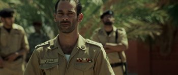 Movie still from “The Kingdom” (2007), directed by Peter Berg – A man in a military uniform is looking to his left; Medium shot, Over the shoulder angle