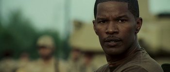 Movie still from “The Kingdom” (2007), directed by Peter Berg – A man's face in a brown shirt; Close Up shot, Over the shoulder angle