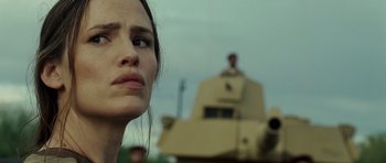 Movie still from “The Kingdom” (2007), directed by Peter Berg – A person in front of a tank; Close Up shot, Low angle