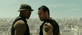 Movie still from “The Kingdom” (2007), directed by Peter Berg – Two men standing next to each other on top of a building; Close Up shot, Over the shoulder angle