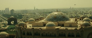 Movie still from “The Kingdom” (2007), directed by Peter Berg – An aerial view of a city with a large building; Extreme Wide shot, High angle
