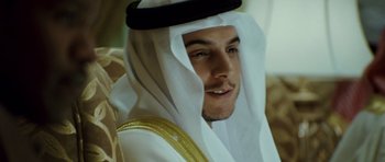 Movie still from “The Kingdom” (2007), directed by Peter Berg – A person wearing a hat; Close Up shot, Over the shoulder angle