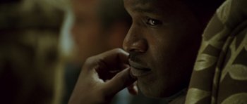Movie still from “The Kingdom” (2007), directed by Peter Berg – A man with his hand to his face; Close Up shot, Low angle