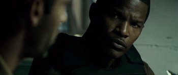 Movie still from “The Kingdom” (2007), directed by Peter Berg – A man's face in the dark; Close Up shot, Over the shoulder angle