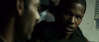 Movie still from “The Kingdom” (2007), directed by Peter Berg – A man with his mouth wide open looking at another man; Close Up shot, Over the shoulder angle