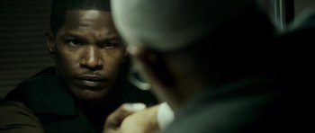 Movie still from “The Kingdom” (2007), directed by Peter Berg – A man looking into a mirror while holding a cell phone to his ear; Close Up shot, Over the shoulder angle