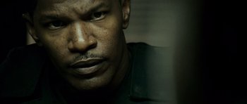 Movie still from “The Kingdom” (2007), directed by Peter Berg – A man's face in a dark room; Close Up shot, Over the shoulder angle