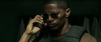 Movie still from “The Kingdom” (2007), directed by Peter Berg – A person talking on a cell phone; Close Up shot, Low angle