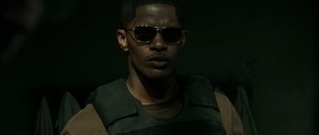 Movie still from “The Kingdom” (2007), directed by Peter Berg – A person wearing sunglasses; Close Up shot, Low angle