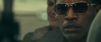 Movie still from “The Kingdom” (2007), directed by Peter Berg – A person wearing sunglasses; Extreme Close Up shot, Low angle