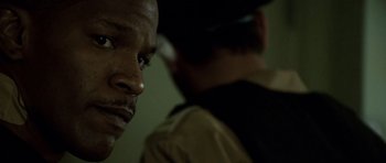 Movie still from “The Kingdom” (2007), directed by Peter Berg – A man in a brown shirt and a man in a black shirt; Close Up shot, Over the shoulder angle