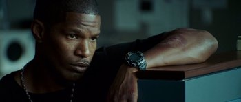 Movie still from “The Kingdom” (2007), directed by Peter Berg – A person wearing a watch on his wrist; Close Up shot, Low angle