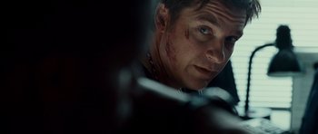 Movie still from “The Kingdom” (2007), directed by Peter Berg – A person with a knife in his hand; Close Up shot, Over the shoulder angle