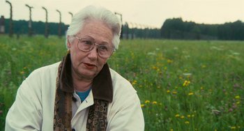 Movie still from “The Last Days” (1998), directed by James Moll – An older woman wearing glasses in a field of flowers; Close Up shot, Over the shoulder angle