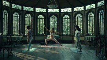 Movie still from “The Midnight Club” (2022), created by Mike Flanagan – Three women are practicing yoga in a large room; Wide shot, Low angle