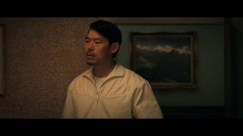 Movie still from “The Midnight Club” (2022), created by Mike Flanagan – A man standing in front of a painting in a room; Medium shot, Low angle