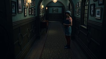 Movie still from “The Midnight Club” (2022), created by Mike Flanagan – A woman standing in the hallway of a building; Wide shot, High angle