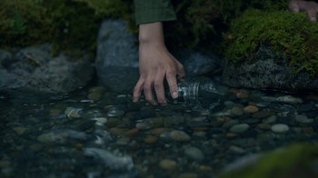 Movie still from “The Midnight Club” (2022), created by Mike Flanagan – A hand reaching for a water bottle in a stream; Extreme Close Up shot, High angle
