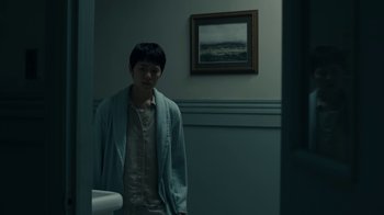 Movie still from “The Midnight Club” (2022), created by Mike Flanagan – A man standing in front of a bathroom mirror; Medium shot, Low angle