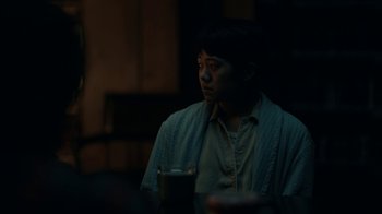 Movie still from “The Midnight Club” (2022), created by Mike Flanagan – A man sitting at a table with a cup of coffee; Medium shot, Over the shoulder angle