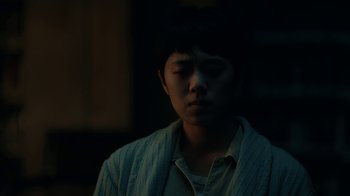 Movie still from “The Midnight Club” (2022), created by Mike Flanagan – A young man in a white shirt is looking down at his face; Close Up shot, Low angle