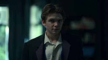 Movie still from “The Midnight Club” (2022), created by Mike Flanagan – A man in a suit and tie looking at the camera; Close Up shot, Over the shoulder angle