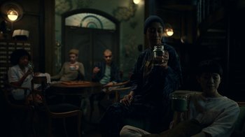 Movie still from “The Midnight Club” (2022), created by Mike Flanagan – Three people are sitting in a room and one is holding a cup; Medium shot, Low angle