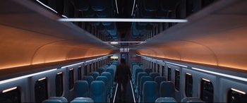 Movie still from “Bullet Train” (2022), directed by David Leitch – A person walking down the aisle of an empty train car; Extreme Wide shot, High angle