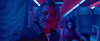 Movie still from “Bullet Train” (2022), directed by David Leitch – A man with long hair and a beard is standing in a room; Close Up shot, Low angle