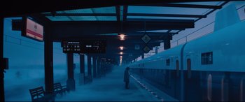 Movie still from “Bullet Train” (2022), directed by David Leitch – A person standing on a train platform near a train; Extreme Wide shot, Low angle