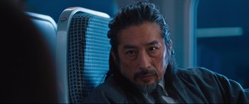 Movie still from “Bullet Train” (2022), directed by David Leitch – A person sitting in a chair; Close Up shot, Over the shoulder angle