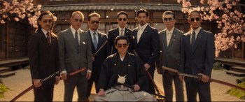 Movie still from “Bullet Train” (2022), directed by David Leitch – A group of men standing next to each other in suits; Medium shot, Low angle