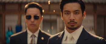 Movie still from “Bullet Train” (2022), directed by David Leitch – Two men in suits and ties standing next to each other; Close Up shot, Low angle