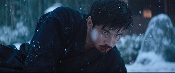 Movie still from “Bullet Train” (2022), directed by David Leitch – A person with blood on his face; Medium shot, Low angle