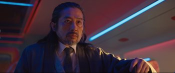 Movie still from “Bullet Train” (2022), directed by David Leitch – A person wearing a suit and tie; Close Up shot, Low angle