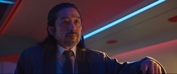 Movie still from “Bullet Train” (2022), directed by David Leitch – A person wearing a suit and tie; Close Up shot, Low angle